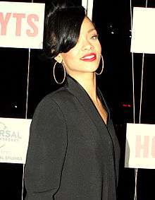 A woman with black hair dressed in a black outfit