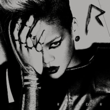 A black-and-white image of a woman wearing a leather jacket. Her hair is side-shaved, wears dark lipstick and her eye is covered with her hand. In the upper right corner there is an metal 'R' sign, while in the down right corner the words 'Rated R' are written in white letters.