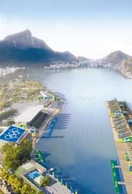 Bird's eye view of rowing lanes placed in a lagoon. There are bleachers around and a mountain in the background.
