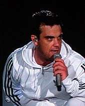 Head and shoulders photograph of Robbie Williams performing live.