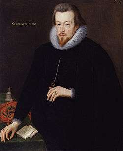 A three-quarter portrait of a white man, dressed entirely in black with a white lace ruff.  He has brown hair, a short beard, and a neutral expression.  His left hand cradles a necklace he is wearing.  His right hand rests on the corner of a desk, upon which are notes, a bell, and a cloth carrying a crest.  Latin text on the painting reads "Sero, Sed, Serio".