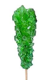 Green sugar crystals on a stick, called rock candy