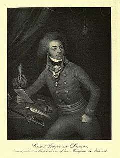 Black and white print of a man sitting at a desk holding a letter. He wears a military coat with two rows of buttons and a gorget at his collar. He has a thick shock of curly hair about his head and well-defined eyebrows over alert eyes.