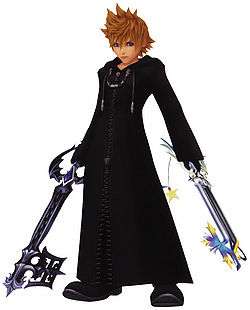 The image shows a young brown-haired blue-eyed kid wearing a black cloak and wielding two key-shaped weapons in his two hands.