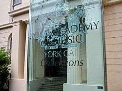 a classical building with a modern sign identifying it as the Royal Academy of Music