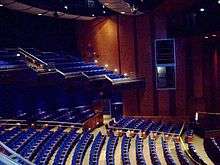 Theater with blue seats and wood paneled walls