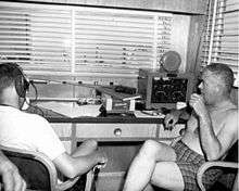 This is a photo of Dr. Walter F. Mazzone and Dr. George Bond inside the communications center of SEALAB I