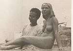 A young Sagini standing beside his statue of a nude woman