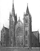 Black-and-white rendering of the front, and part of the side, of a tall, fancy church, and a 5-story parish house next door. The light is from upper left, casting shadows to lower right. There are a few figures on the sidewalk in front of the church, and an open motorcar parked at lower right.