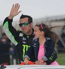 Hornish, in sunglasses, waves while holding his young daughter