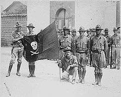 several Marines display a black flag with a white skull and crossbones