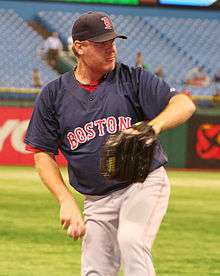 Curt Schilling, in a navy-blue Boston Red Sox jersey, prepares to throw.