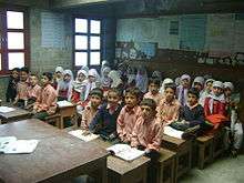 School children in Rhbat, Nagar sit in classroom learning. The boys are in the front with the girls behind them.