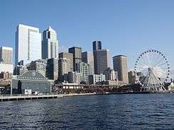 Vew of the downtown Seattle skyline, on the waterfront, with the Seatle Aquarium on the left and Seattle Great Wheel on the right.
