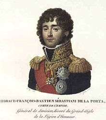 Colored print of a curly-haired and clean-shaven man. He wears a dark blue uniform with gold epaulettes, a high gold collar and a red sash.