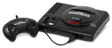 Black video game console with top-loading slot and single, wired controller with directional pad and four buttons