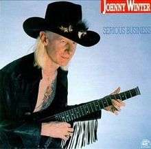 Johnny Winter, wearing a broad-brimmed hat and playing a guitar