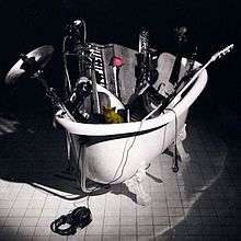 A pile of musical instruments inside of a white bath.