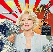 A woman has powder make-up applied to her face as she is surrounded by ukiyoe imagery, an airplane and a guitar.