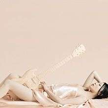 A mostly naked woman reclining, holding a Gibson SG guitar.