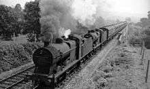 Black and white photograph of a steam engine and carriages in motion