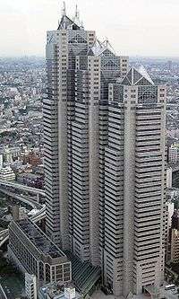 Aerial view of a beige high-rise lined with rows of windows; the building is composed of three adjoined towers of differing heights