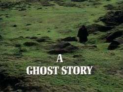 The image is the title screen of the adaptation of "The Signalman". A lone traveller, wearing black Victorian travelling garments and silhouetted so that he cannot be identified, treads across green fields pockmarked by molehills. He is walking towards the camera. A slightly muggy, cloudy atmosphere pervades the image. The strand title "A Ghost Story" is superimposed over this in bold, white capital letters.