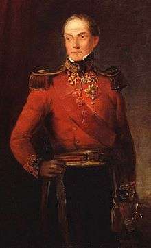 Painting of a standing man with his right hand on his hip. He wears a red military coat and dark blue trousers.