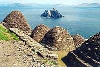 view over Skellig Michael showing stone beehive structures and Small Skellig island in the distance