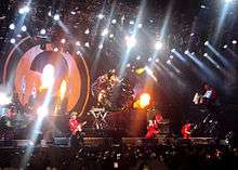 Several members of Slipknot performing on stage, spotlit
