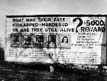 A black and white photograph of a billboard with pictures of five children and large text asking "What was their fate? Murdered? Kidnapped? Or are they still alive?" and "$5000 reward"