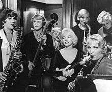 Monroe, Curtis and Lemmon playing instruments with other musicians in the orchestra