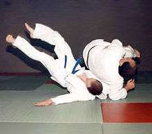 Judoka demonstrate a dynamic soto-makikomi