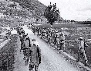Lines of troops marching along a road