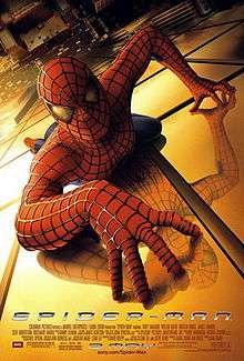 Spider-Man, in his famous suit, crawling over a building, looking towards the viewer, below of him there is New York City and the film's title, credits and release date.