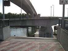 A concrete portion of a bridge being swung over water