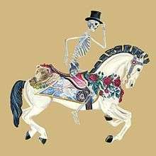 A skeleton with a top hat rides a merry-go-round horse