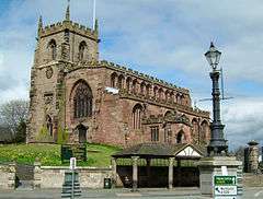 A stone Gothic church with a battlemented tower and body