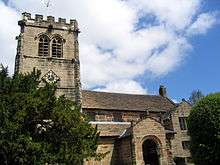 A stone church with a battlemented Gothic tower