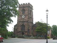 The battlemented tower of a stone Gothic church