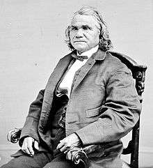 Formal photograph of a seated Stand Watie, in European dress