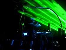 Dirk Brossé conducting as green lasers shine in the background