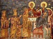 A bearded man who wears a crown offers a church to Christ who sits on a throne; the man is surrended by a crowned woman and man and a child