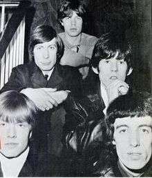 Black-and-white photograph of The Rolling Stones sitting on a staircase in 1965.