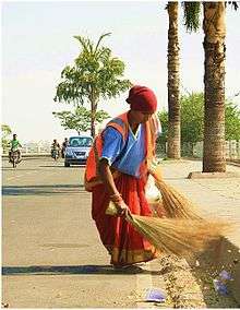 Woman sweeping the road