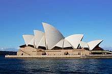 The Sydney Opera House appears to float on the harbour. It has numerous roof-sections which are shaped like huge shining white sails