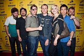 Seven of the filmmakers posing for a photo on the red carpet.