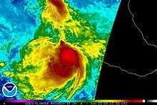 Colorized infrared satellite image of a tropical storm near the west coast of central Mexico. Intense convective activity, such as strong thunderstorms, are depicted by areas of bright red, concentrated around the center of the storm.