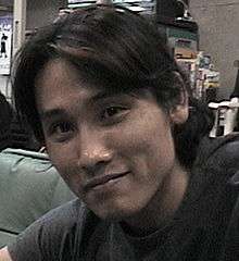 A smiling Japanese man with black hair.