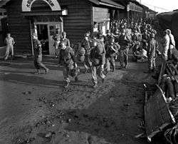 Soldiers carrying their bags off of a train in Daejeon train station, South Korea
